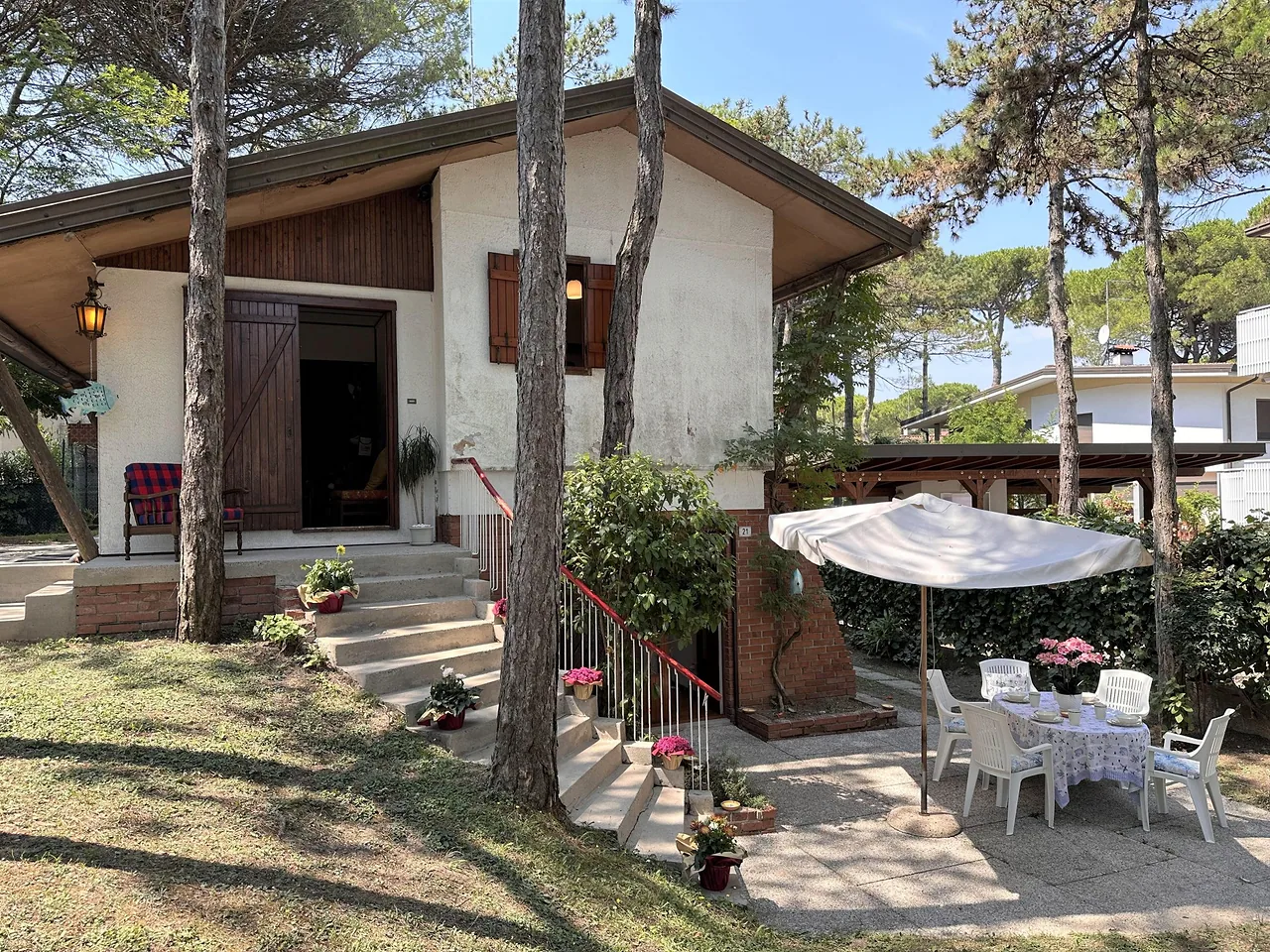 Villa nel verde con patio, ombrellone e tavolo apparecchiato