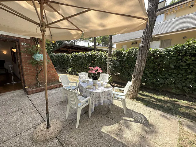 Patio con gazebo, tavolo apparecchiato e fiori
