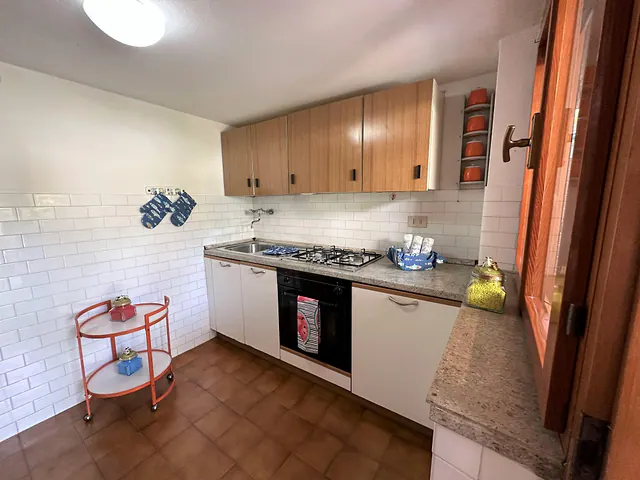 Cucina con piano cottura a gas, forno e carrello