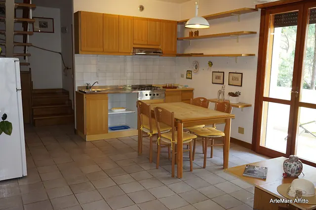 Cucina in legno con scala verso il piano superiore