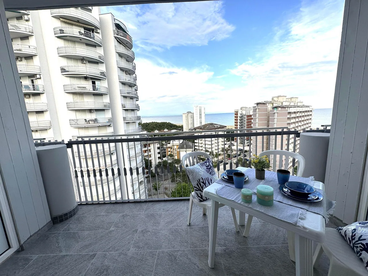 Balcone con tavolo apparecchiato e panorama su Lignano Sabbiadoro