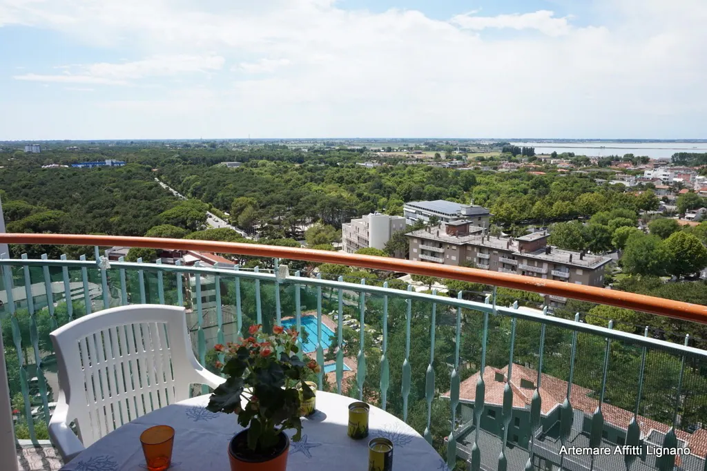 Balcone al 13° piano con tavolo e vista panoramica su Lignano