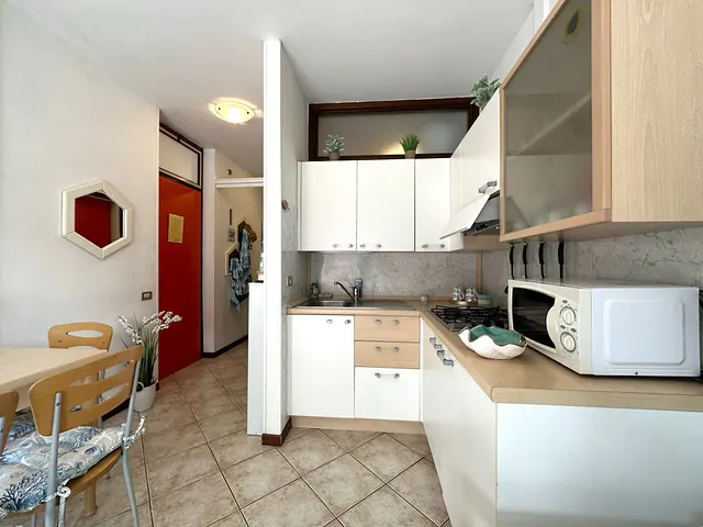 Angolo cottura bianco con microonde e porta d'ingresso