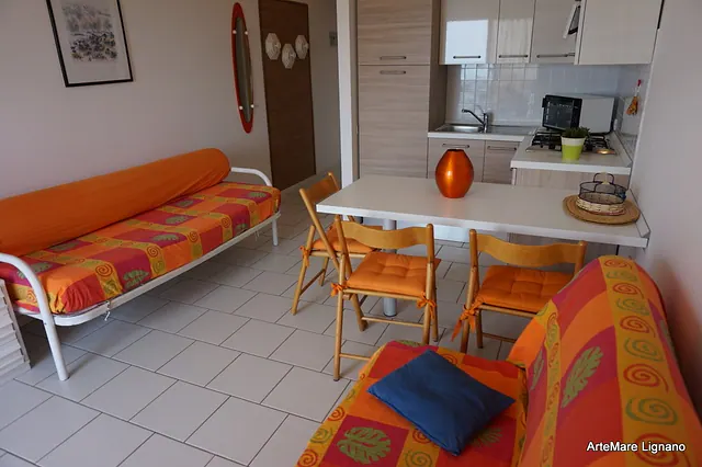 Soggiorno con divano letto, tavolo e angolo cottura