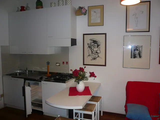 Angolo cottura bianco con tavolino e fiori