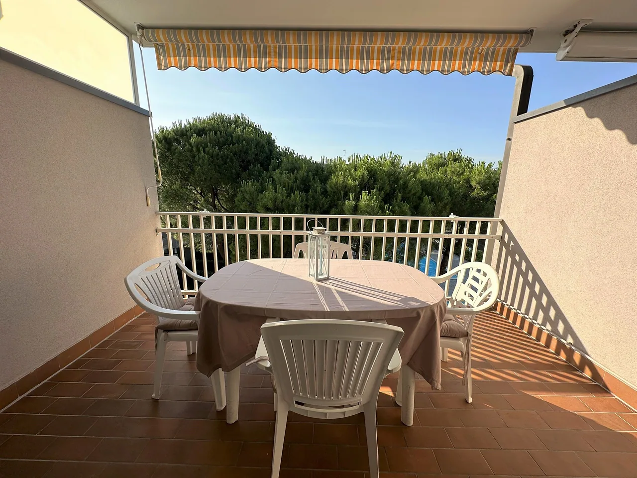 Terrazzo attrezzato con tavolo e sedie affacciato sui pini