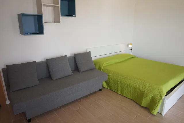 Letto matrimoniale verde e divano letto grigio
