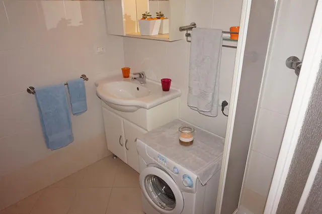 Bagno con lavatrice, lavabo e asciugamani