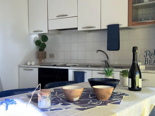 Angolo cottura con lavello e tavolo apparecchiato