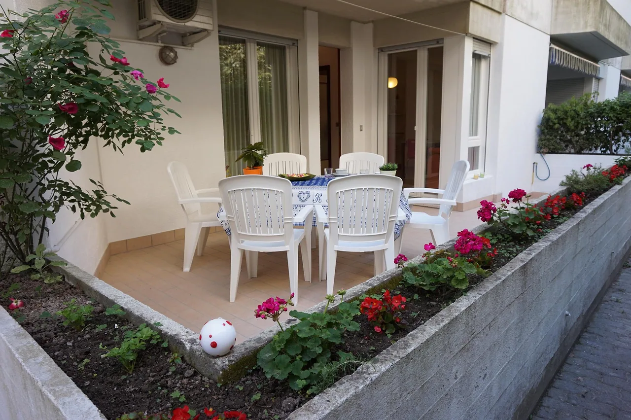 Patio con tavolo, sedie e fioriere colorate