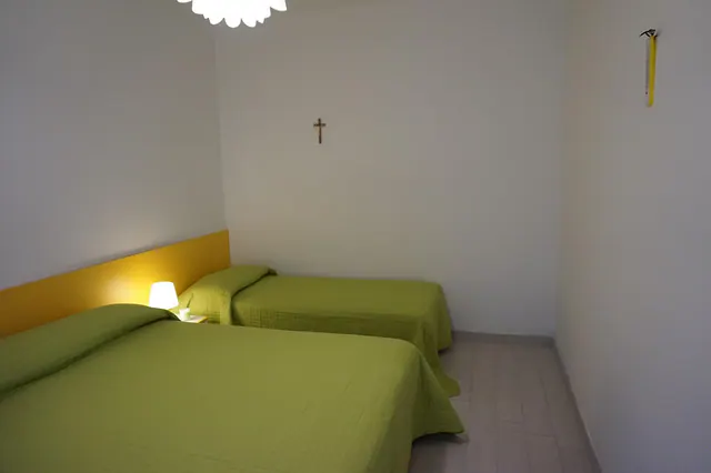 Camera con letti singoli e copriletti verdi