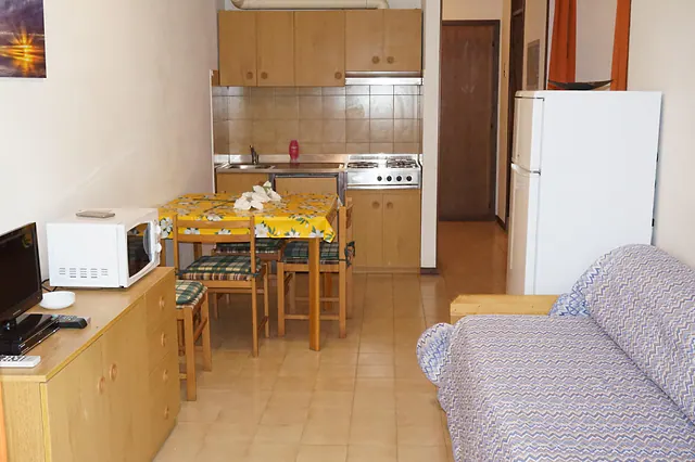Monolocale con angolo cottura, tavolo e divano letto
