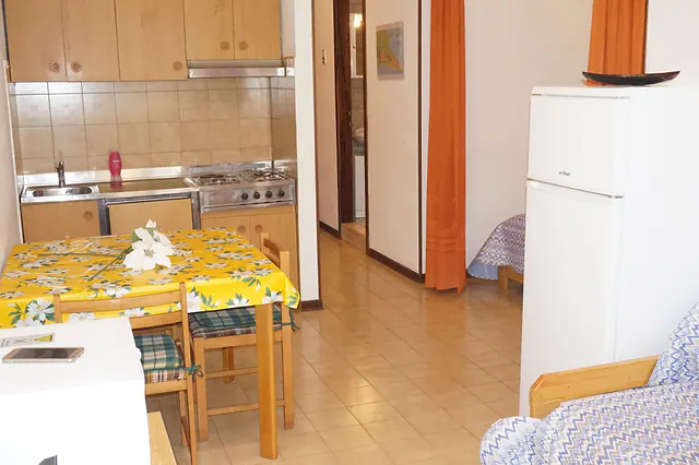 Angolo cottura con tavolo e frigorifero