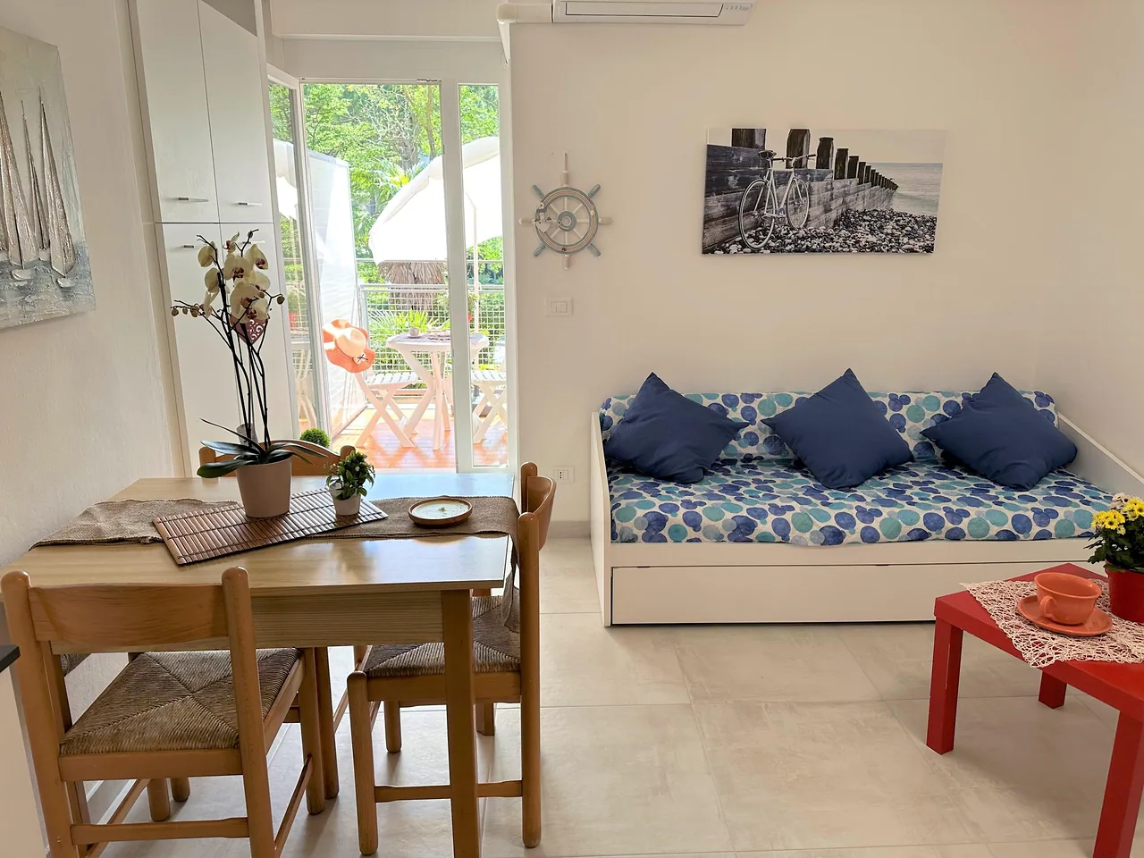 Monolocale luminoso con tavolo apparecchiato e divano letto