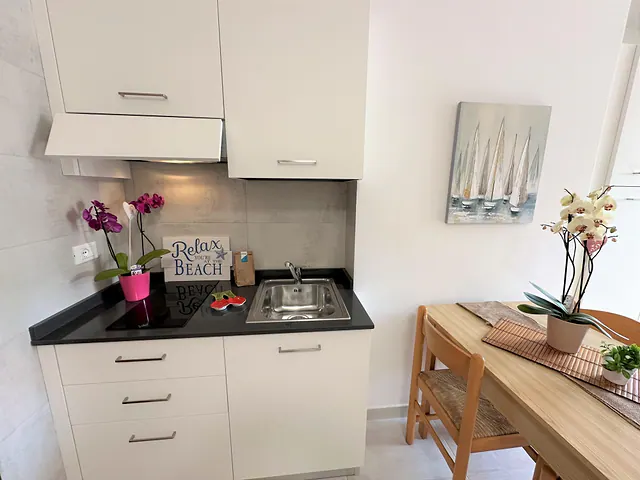Angolo cottura con piano nero e orchidee