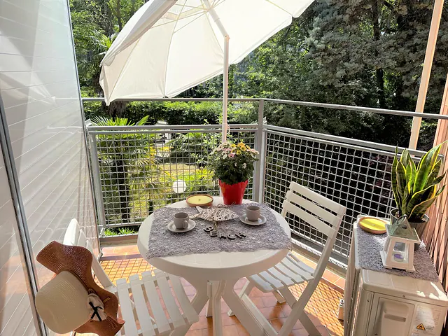 Balcone con colazione servita e ombrellone