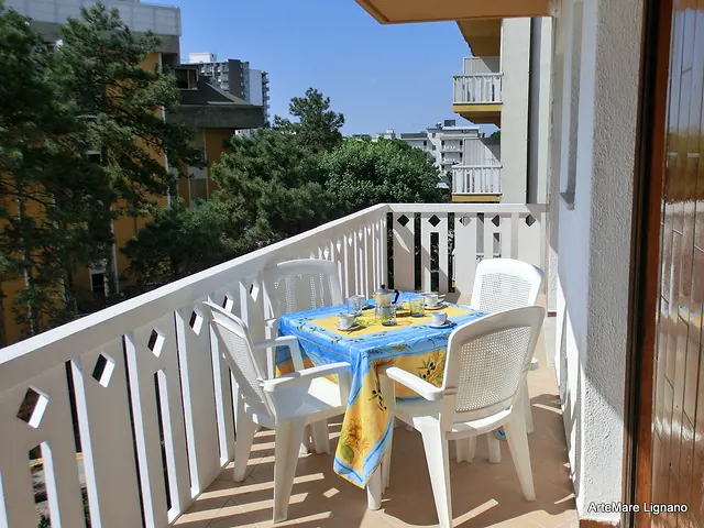Balcone con tavolo apparecchiato e vista sul verde
