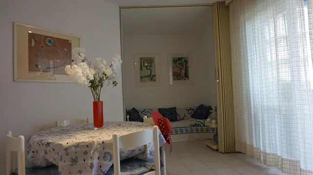 Soggiorno con tavolo apparecchiato e fiori bianchi
