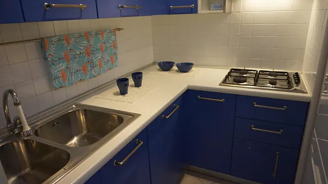 Cucina ad angolo blu con lavello