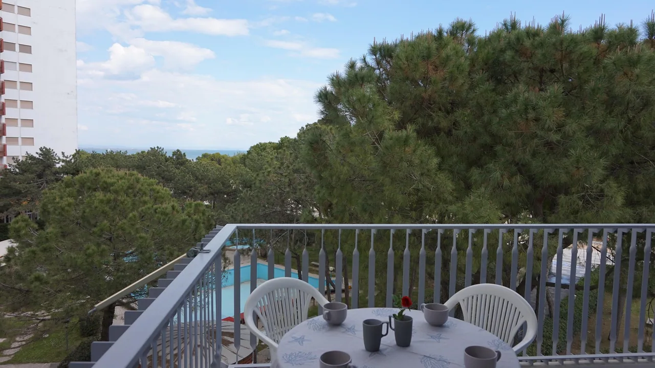 Terrazzo con tavolo apparecchiato e vista sulla pineta e sulla piscina