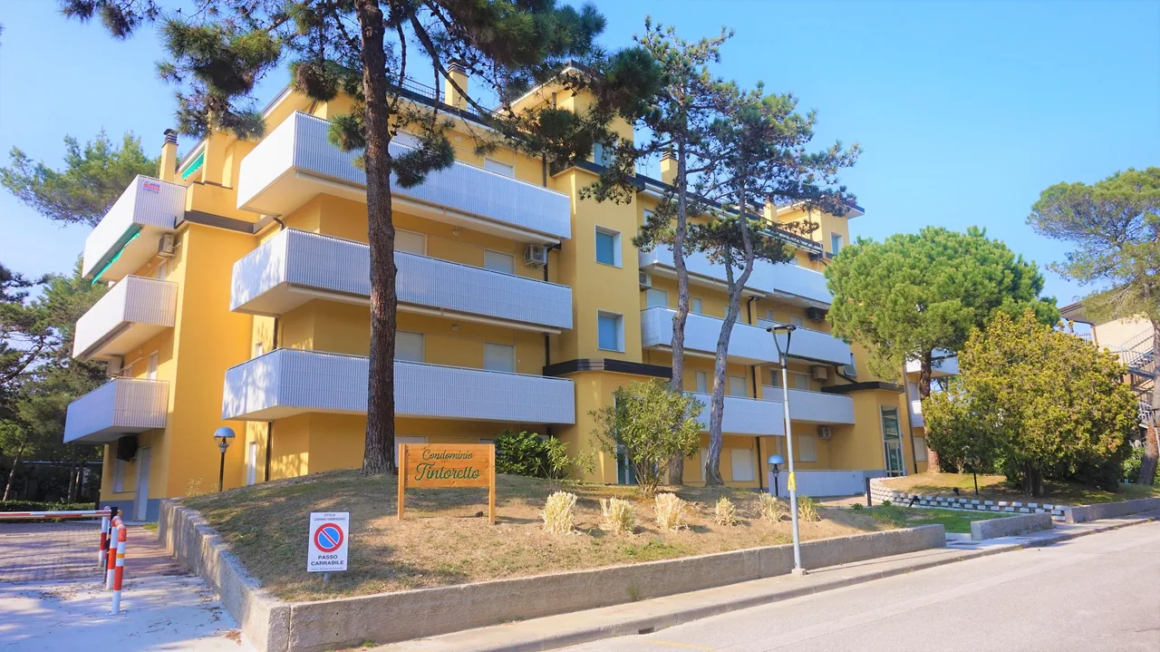 Condominio Tintoretto, palazzina gialla tra i pini