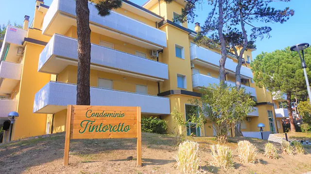 Insegna del Condominio Tintoretto e facciata gialla