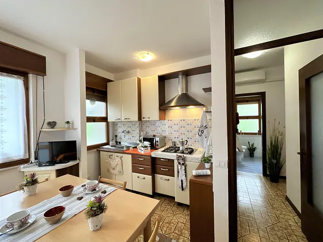 Cucina con cappa in acciaio e tavolo apparecchiato