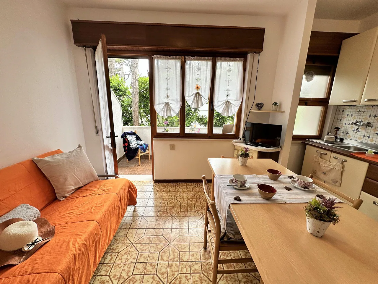 Soggiorno luminoso con divano letto, tavolo e portafinestra