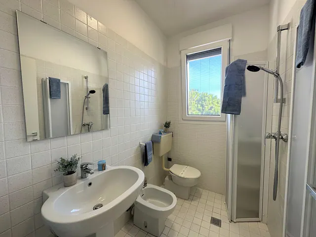 Bagno con finestra, doccia e lavabo