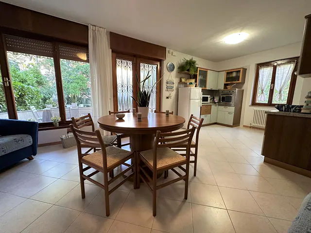 Tavolo da pranzo rotondo e ampie vetrate sul giardino