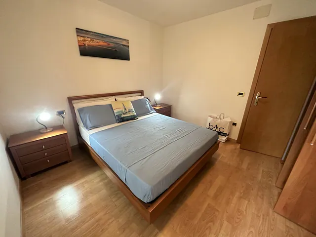 Camera matrimoniale con letto in legno e comodini