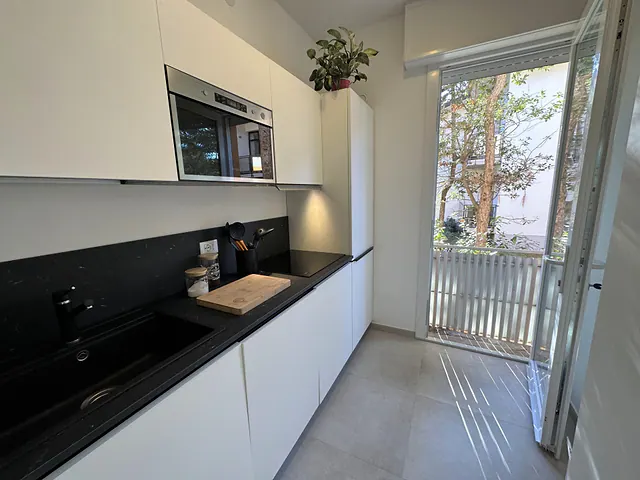 Cucina moderna bianca e nera con portafinestra