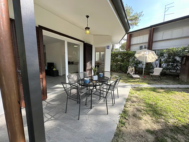 Portico con tavolo e sedie affacciato sul giardino
