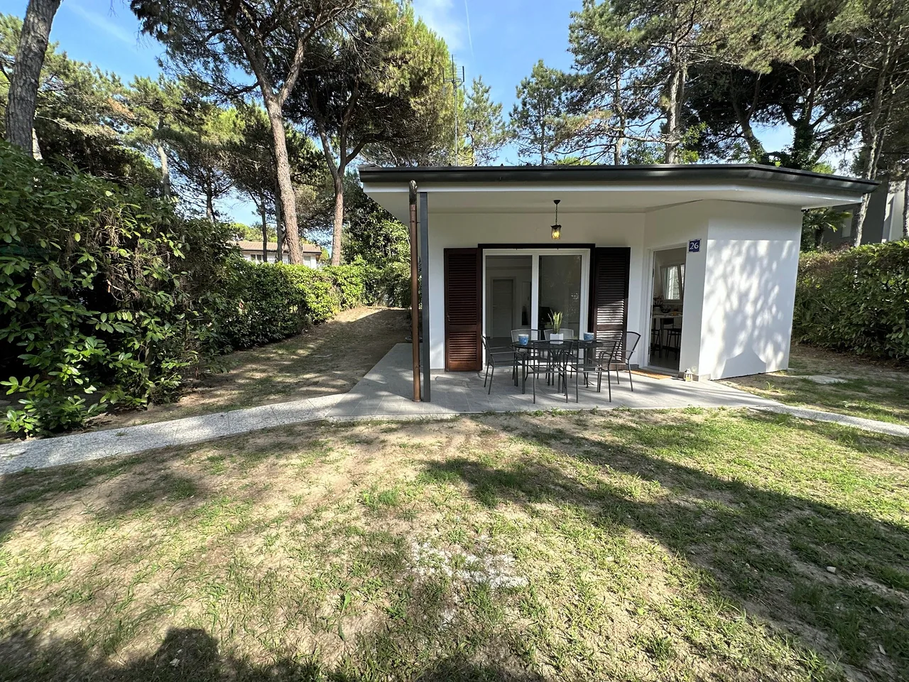 Villa con portico e prato curato tra i pini marittimi