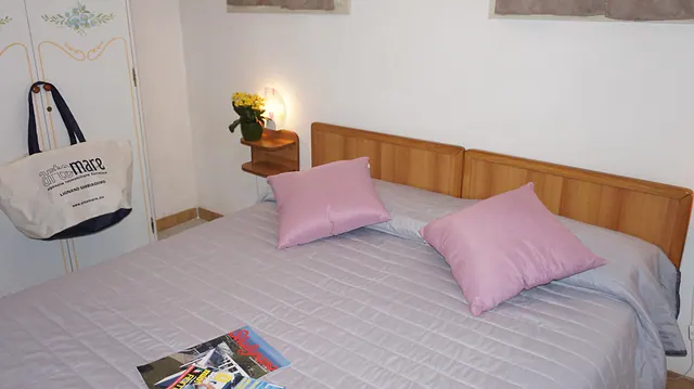 Letto matrimoniale con borsa mare Artemare e fiori