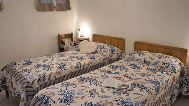 Camera con due letti singoli e copriletti a fantasia marina