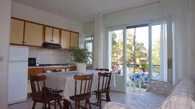 Cucina con tavolo da pranzo e portafinestra sul terrazzo