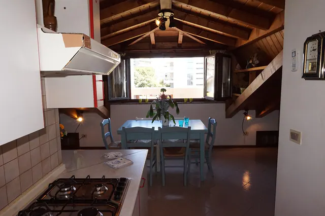 Cucina con piano cottura e zona pranzo mansardata