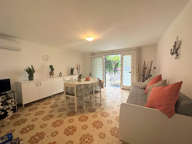 Soggiorno con divano, tavolo e portafinestra sul patio