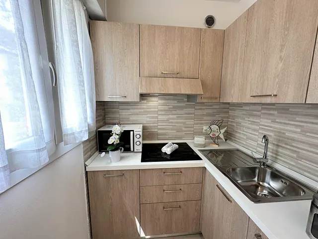 Cucina nuova in legno chiaro con piano cottura a induzione