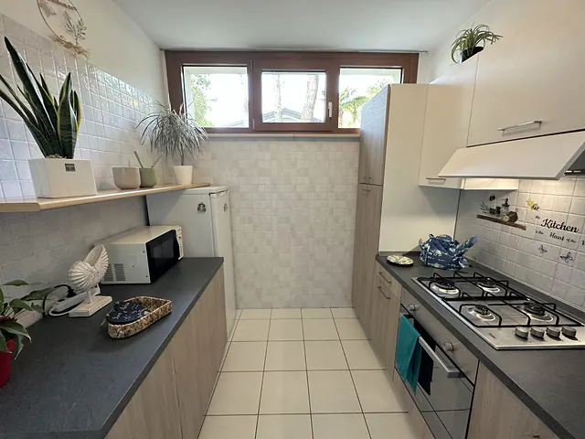 Cucina con piano cottura a gas, forno e finestra