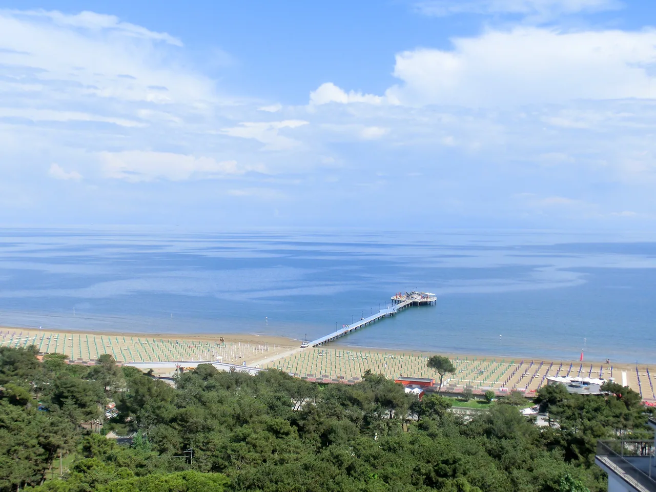 La spiaggia di Lignano Pineta vista dall'alto, con il pontile e la pineta